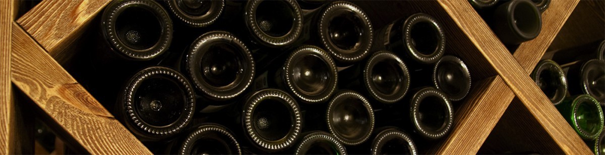 Wine bottles stored on their sides in a wooden diamond-shaped cellar rack