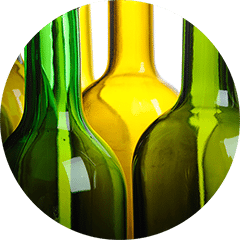 Close-up of empty green and amber glass wine bottles standing side by side
