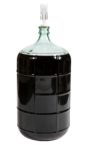 Glass carboy filled with dark red wine and fitted with a three-piece airlock